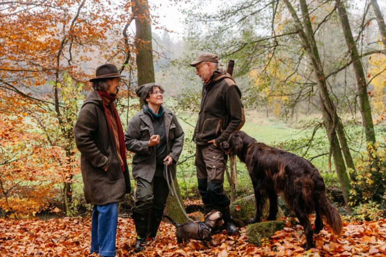 Menschen und Hunde im herbstlichen Wald