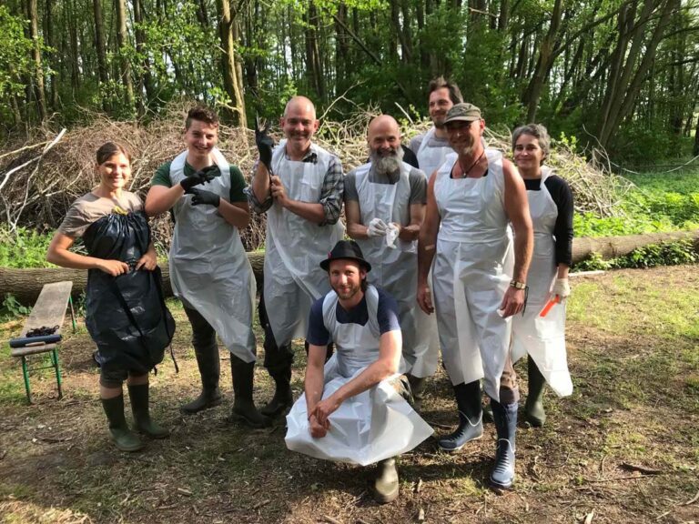 Gruppe in weißen Schürzen im Wald