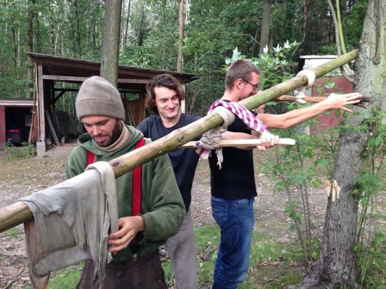 Männer bauen im Wald ein Gestell.