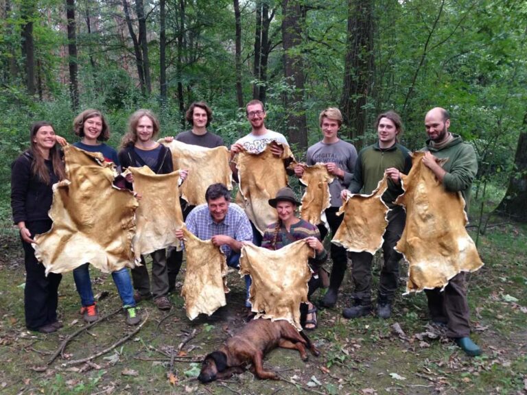 Gruppe hält Tierhäute im Wald.