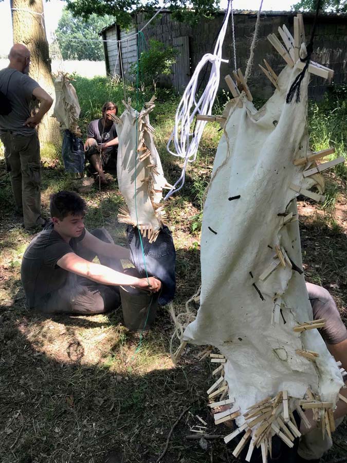 Personen bearbeiten Tierhäute im Freien