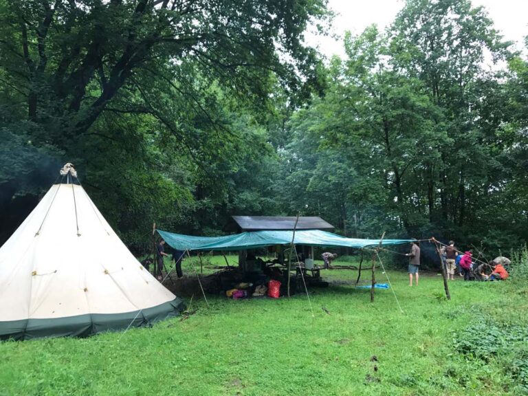 Zeltlager im Wald mit mehreren Personen
