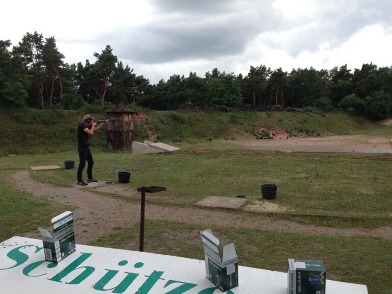 Person schießt draußen in bewaldeter Umgebung