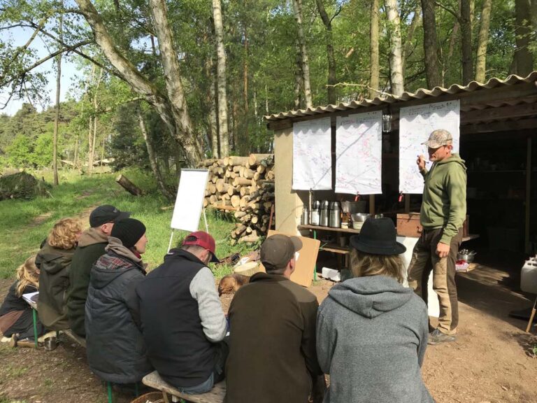 Outdoor-Vortrag vor einer Gruppe im Wald.