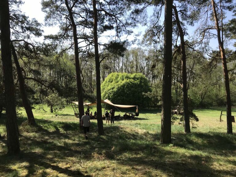 Waldcamp mit Sonnensegeln und Personen