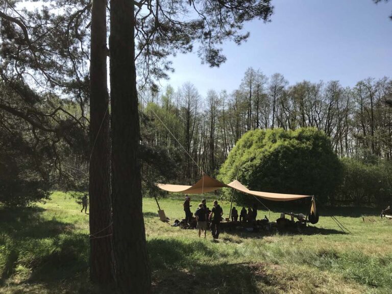 Gruppe zeltet unter Baum im Wald.