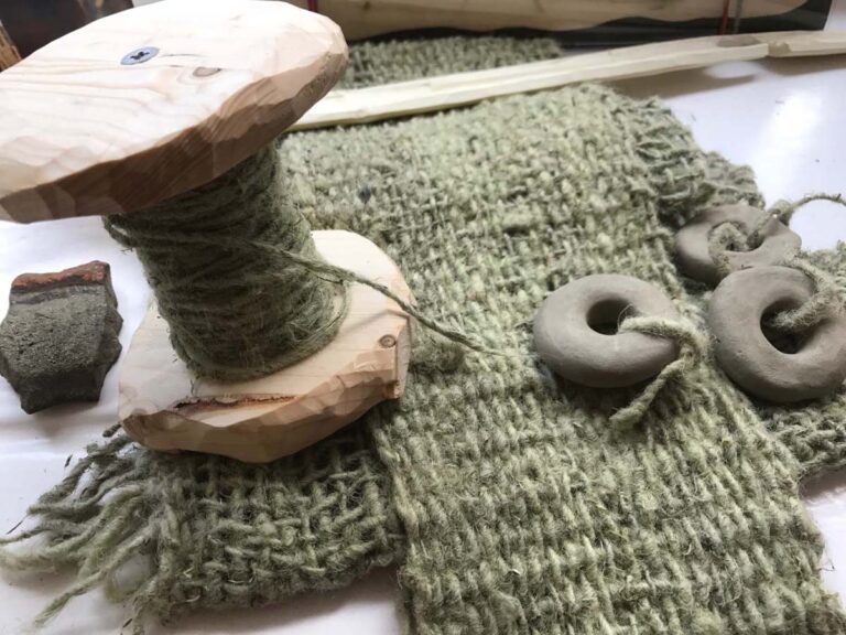 Garnspule mit handgewebtem Stoff und Tonringen