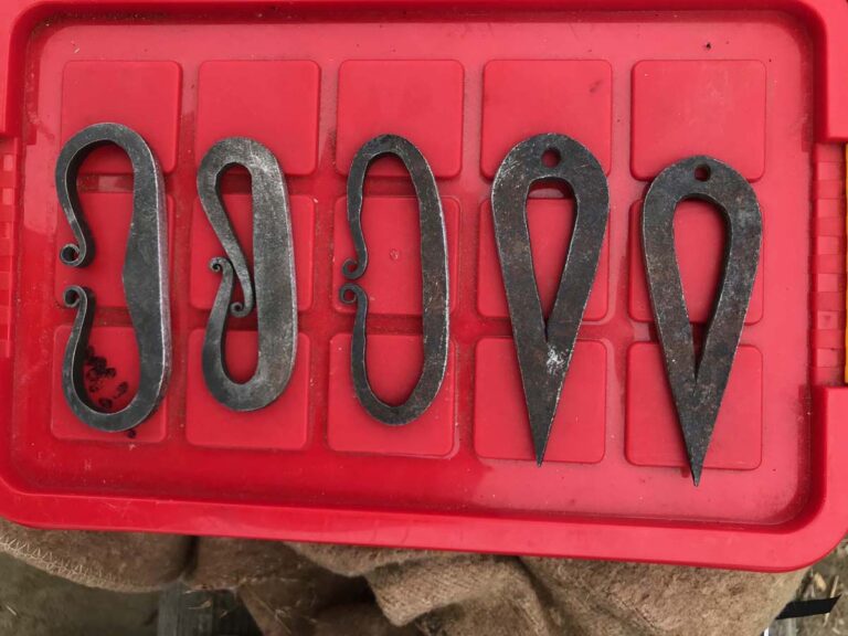 Fünf Feuerstähle auf rotem Hintergrund.