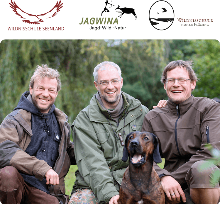 Drei Männer und ein Hund im Freien.