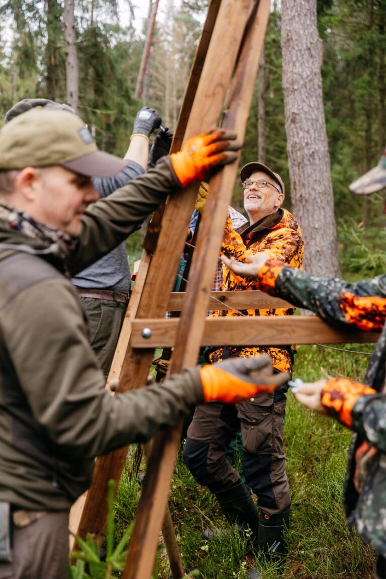 Gruppe errichtet Holzstruktur im Wald