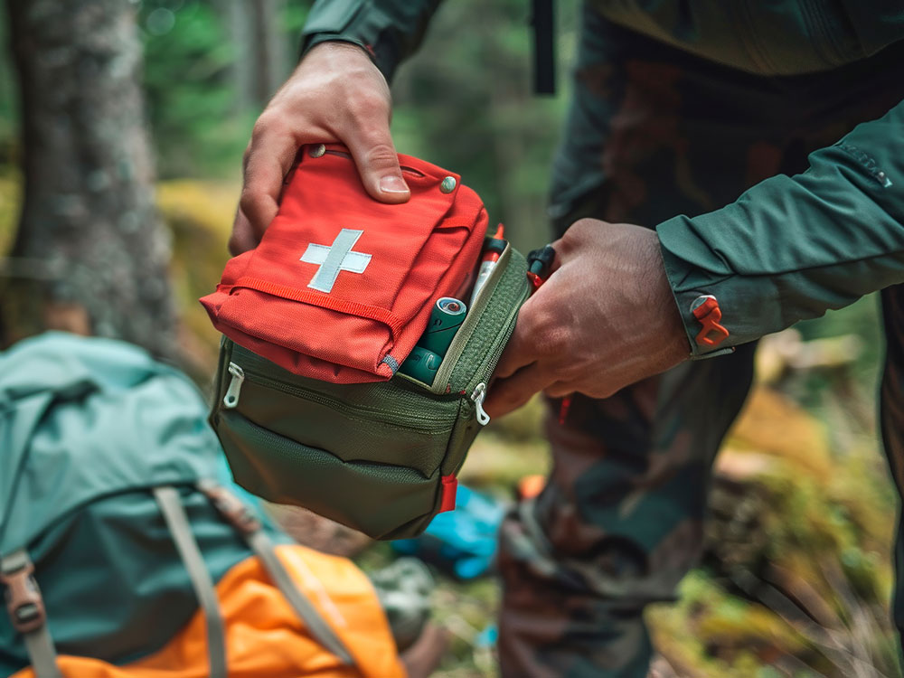 Person packt Erste-Hilfe-Set im Wald.