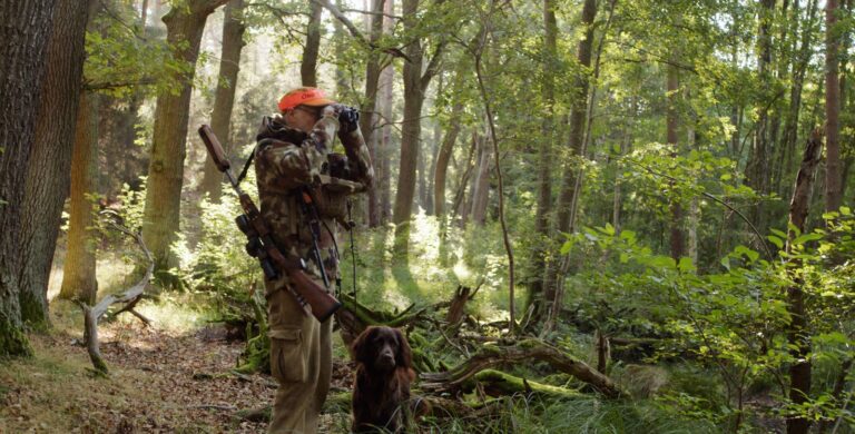 Jäger mit Hund im Wald
