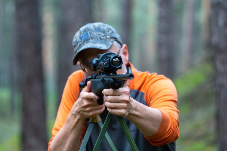 Person mit Gewehr im Wald zielend