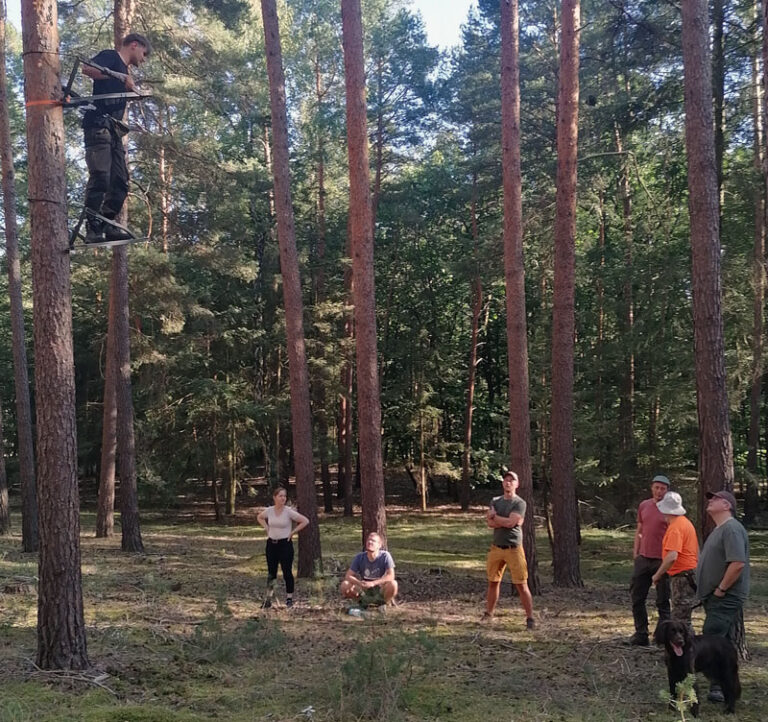 Mann auf Hochsitz im Wald, Zuschauer beobachten.