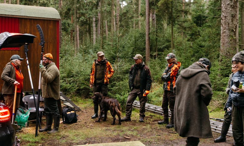 Jägerpause im Wald mit Hund und Ausrüstung
