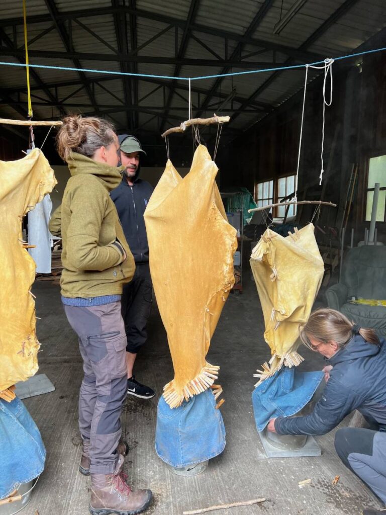Drei Personen beim Räuchern von Leder