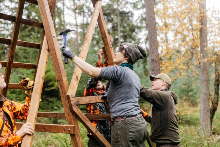Menschen bauen eine hölzerne Struktur im Wald