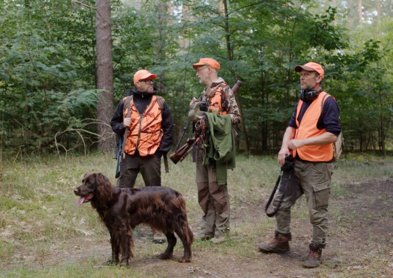 Jäger mit Hund im Wald beim Gespräch