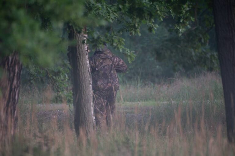 Verschwommene Person im Tarnanzug im Wald