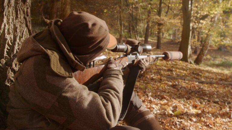 Jäger mit Gewehr im Herbstwald