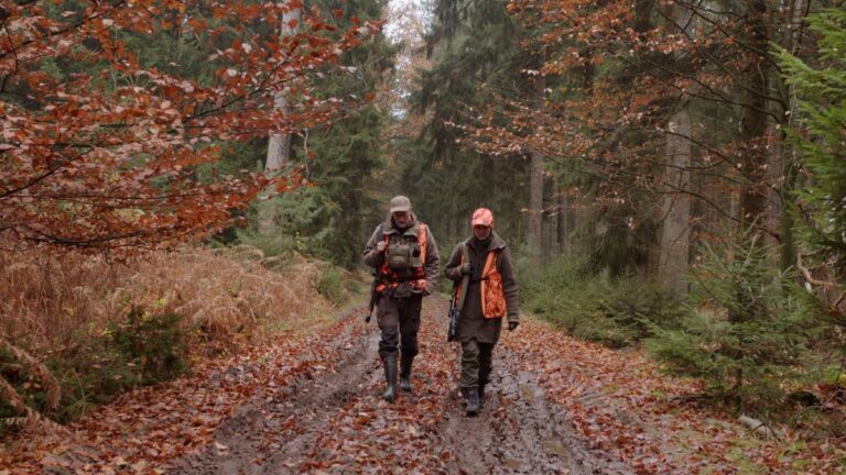 Zwei Jäger im herbstlichen Wald.