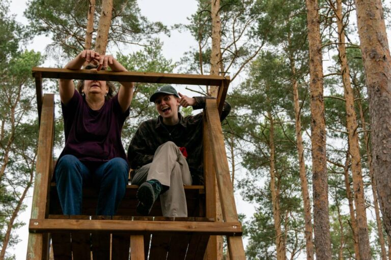 Menschen auf Hochsitz im Wald