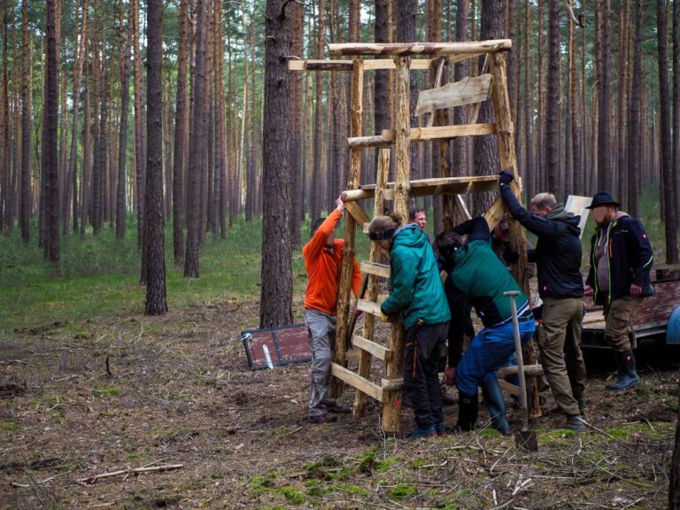 Menschen bauen hölzernen Jagdstand im Wald