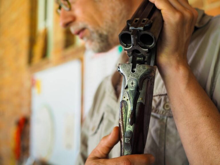 Person hält eine antike doppelläufige Flinte.