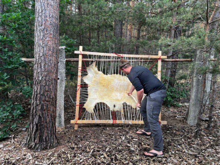 Mann gerbt ein Leder im Rahmen
