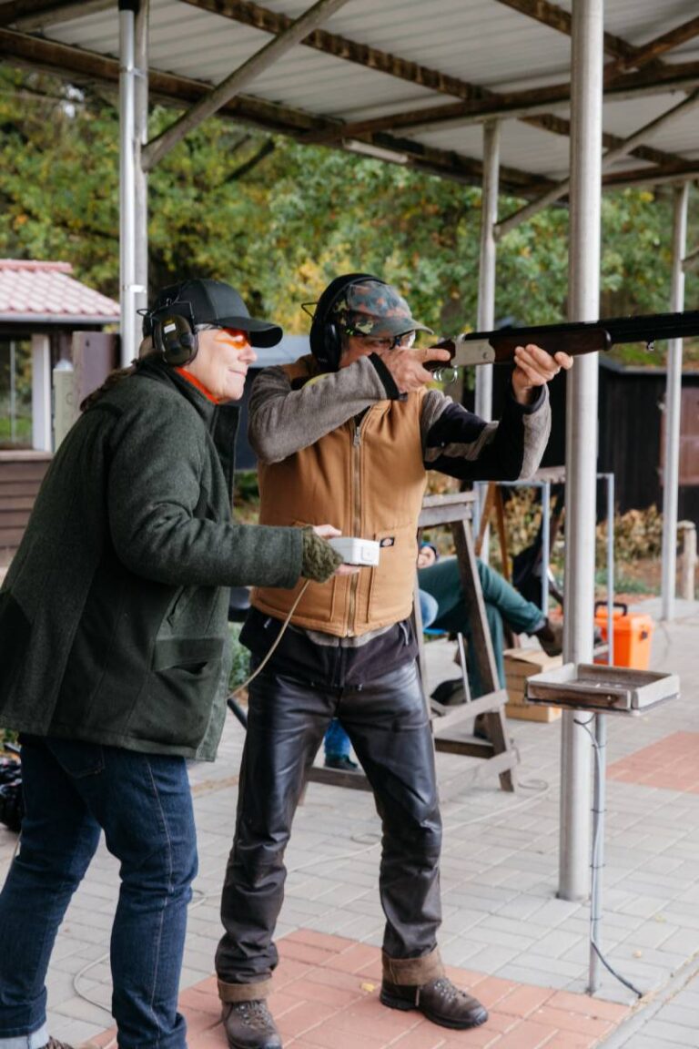 Zwei Personen beim Tontaubenschießen mit Gewehr.