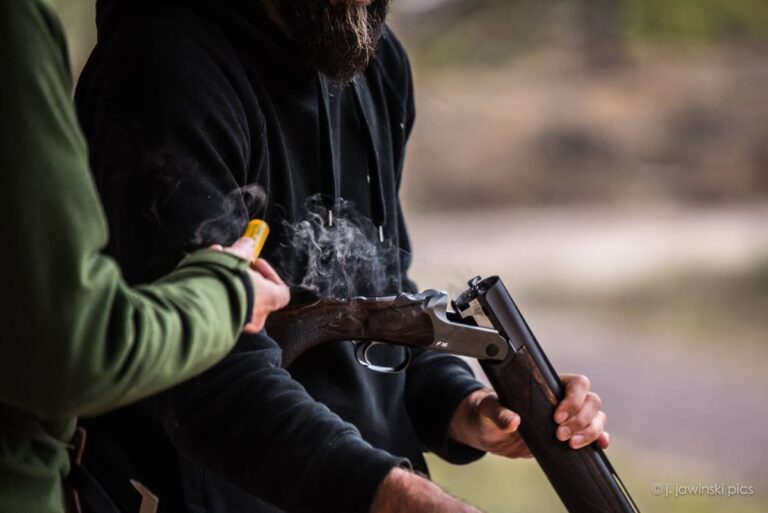 Person mit Flinte und Patronenhülse im Freien