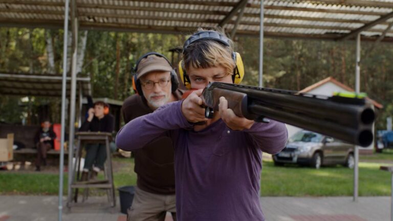 Person zielt mit Gewehr am Schießstand.