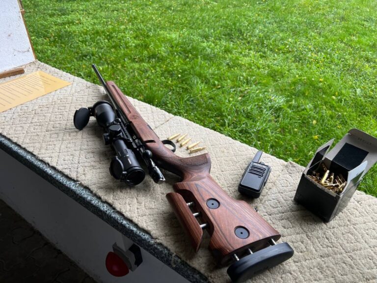 Gewehr auf Schießstand mit Patronen und Funkgerät.