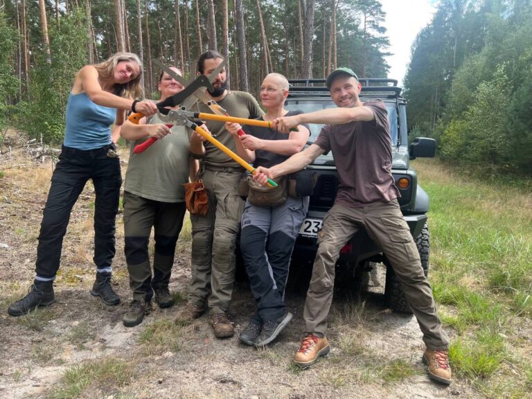 Gruppe mit Astscheren im Wald.