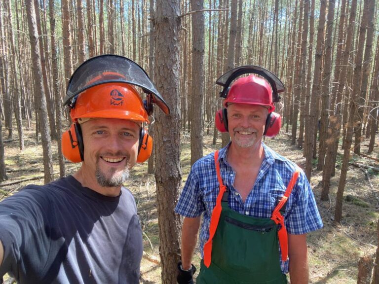 Zwei Männer im Wald mit Schutzhelmen